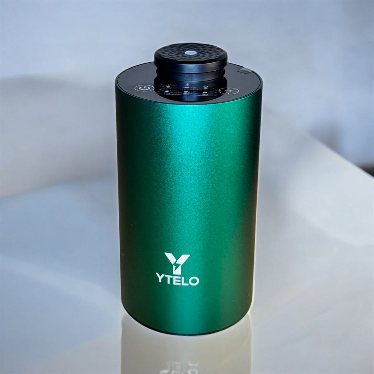 YTELO Emerald Green rechargeable waterless diffuser shown with an amber oil bottle, small adapter components, and a white USB charging cable.